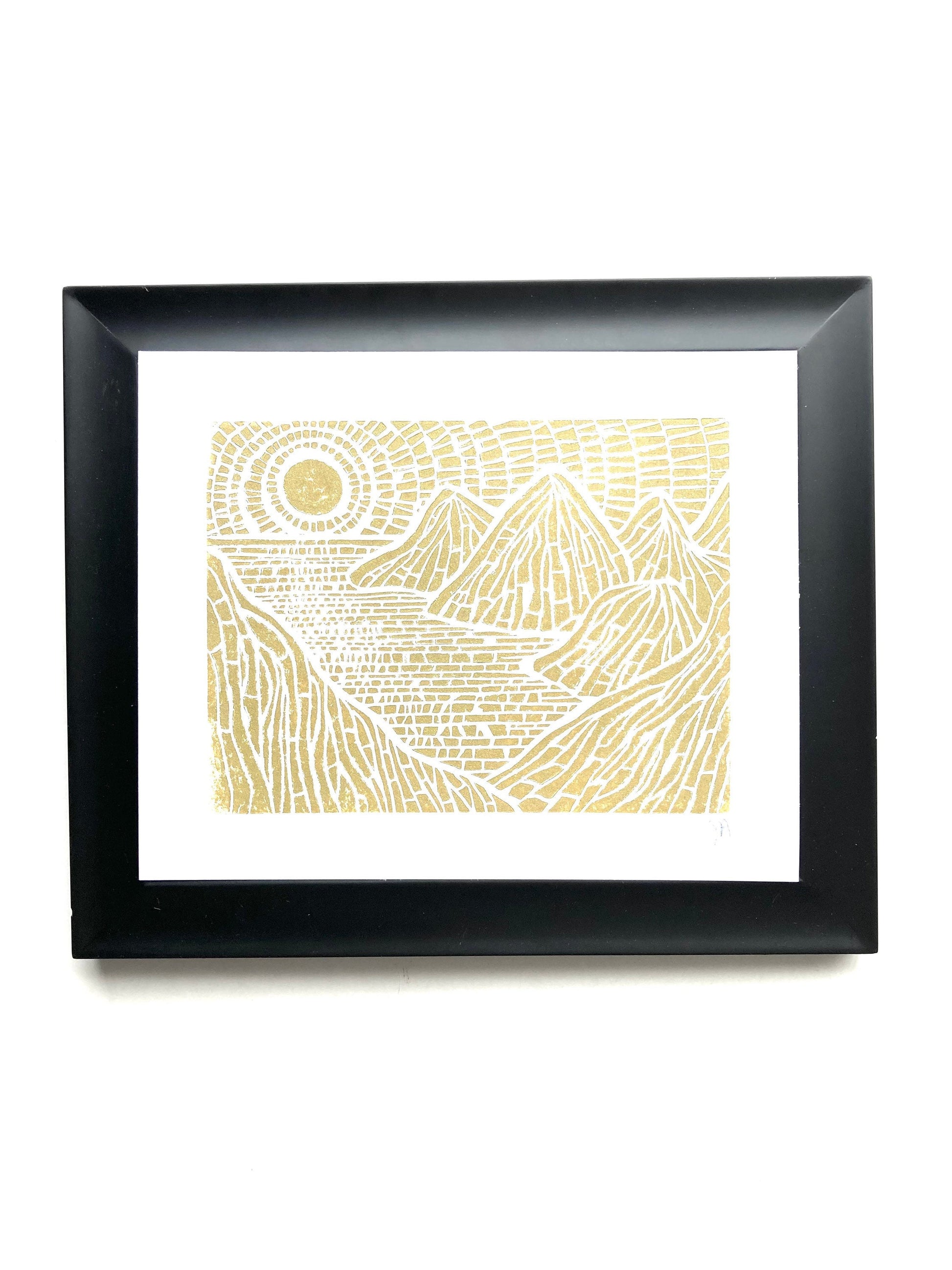Framed artwork with gold islands design on white background