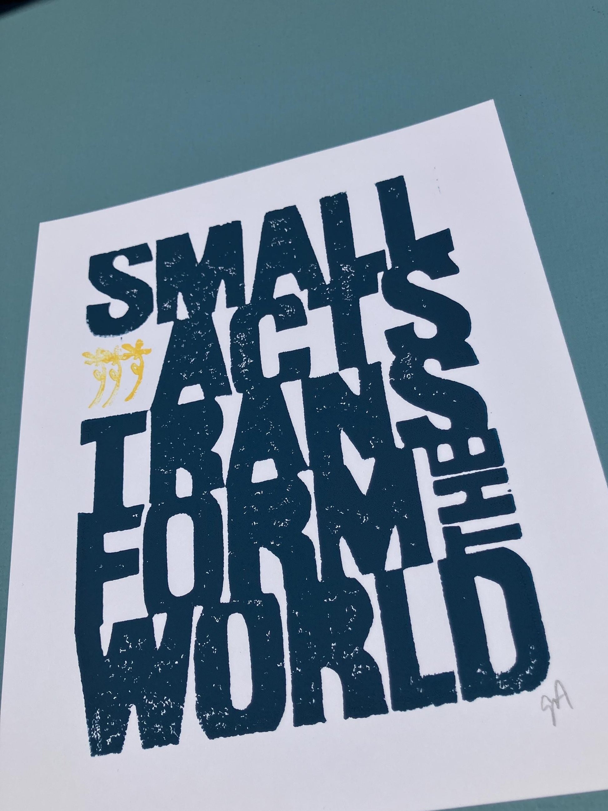 Motivational poster with text 'Small acts transform the world' on a light blue background