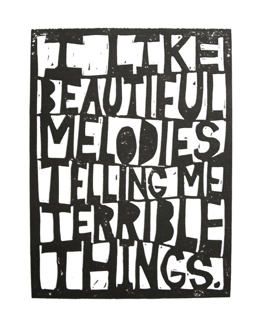 Black and white linocut print reading "I like beautiful melodies telling me terrible things" by Tom Waits and The Big Harumph