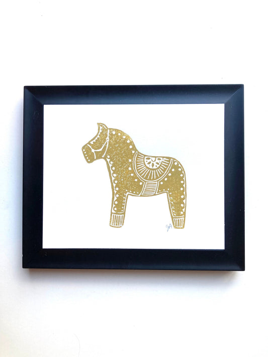 Framed artwork of a gold horse on a white background