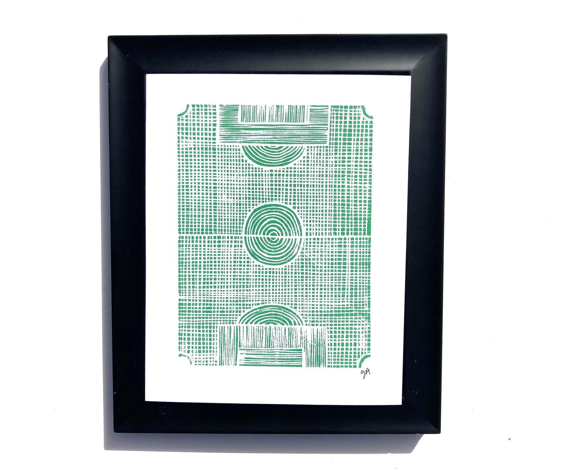 Framed artwork with green geometric pattern of a soccer field on a white background