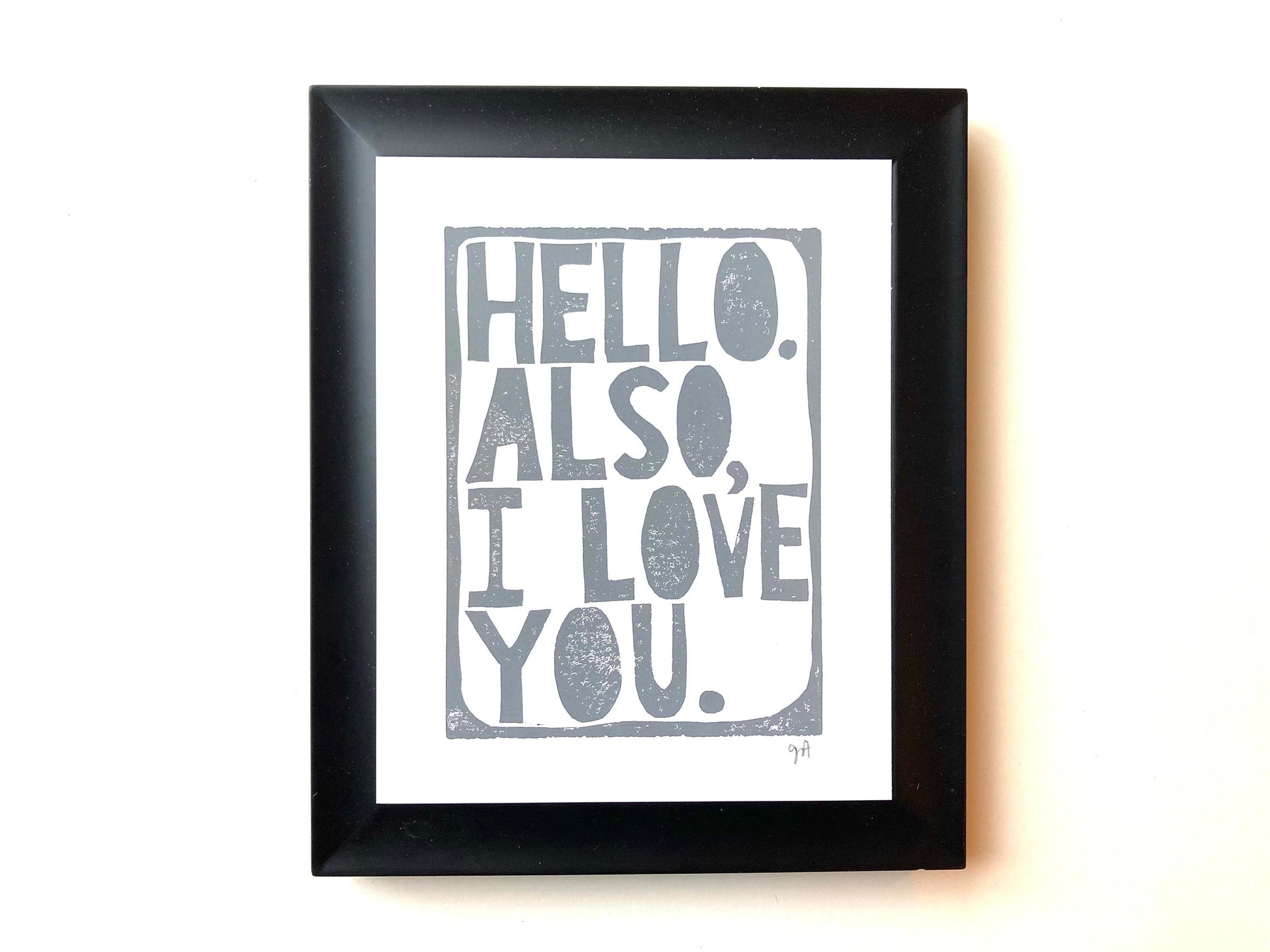 Framed print with 'Hello. Also, I love you.' text on a white background