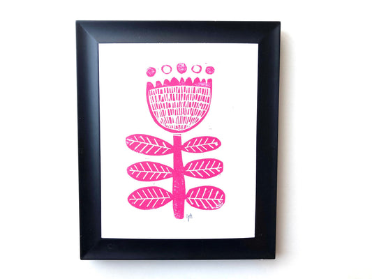 Framed artwork with a pink floral design on a white background