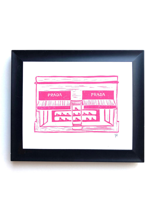 Framed artwork of a pink Prada store illustration on a white background