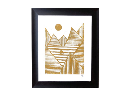 Framed artwork with gold geometric mountain design on a white background