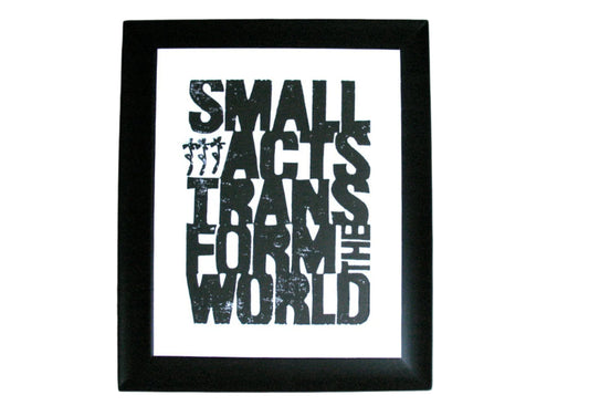Framed linoleum block poster with motivational quote 'Small acts transform the world' by Howard Zinn in black linocut ink on a white background
