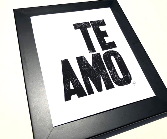 Framed artwork with 'TE AMO' text on a white background